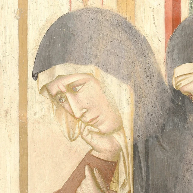 A Poor Clare touches her face with her fingers, her gaze lowered.