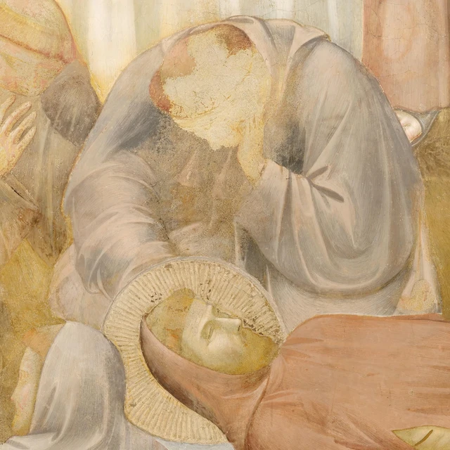 A bearded friar lowers his face as he bends over Francis’s body.