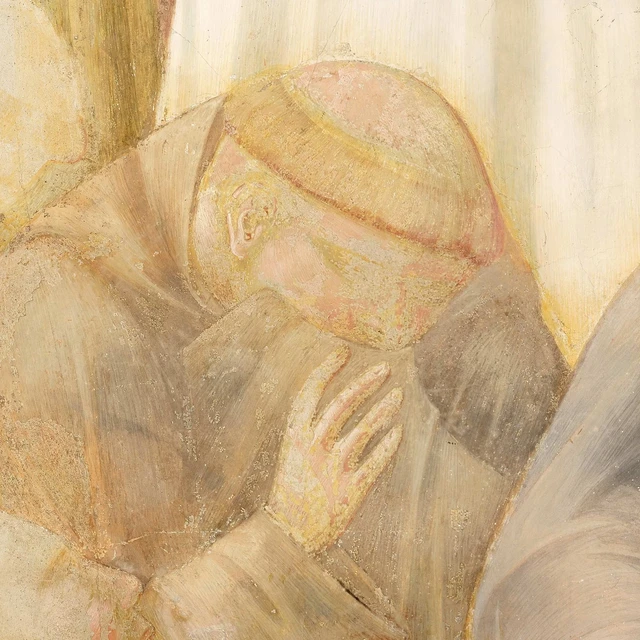 A friar bows his head and raises a hand to his chin beside the dead Francis.