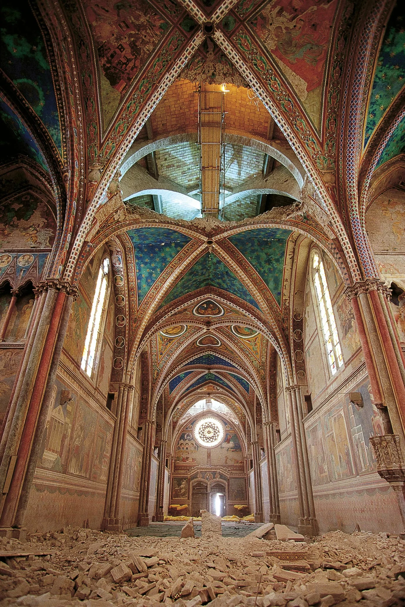 View of the nave after the earthquake, with rubble along the floor and gaps in the vaults.