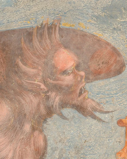 Profile of a reddish demon with an open mouth and pointed beard.
